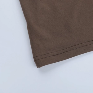 Close-up detail of double-stitched hem on coffee brown A-line dress showing fabric texture