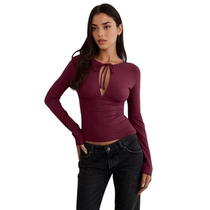 Close-up of burgundy ribbed knit top with teardrop cutout and elegant tie detail