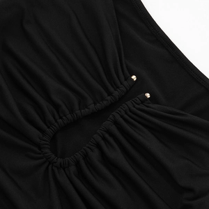 Close-up of black knit fabric with elegant ruched texture and two gold button details