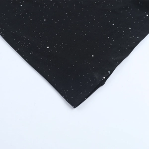 Detail of black knit fabric featuring dense silver glitter and shimmering sequin texture