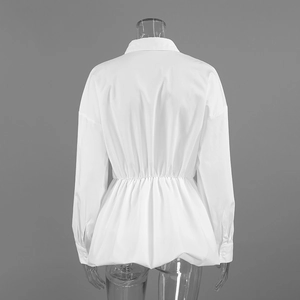 Detail view of white cotton shirt back with elastic waist and ruffled peplum hemline