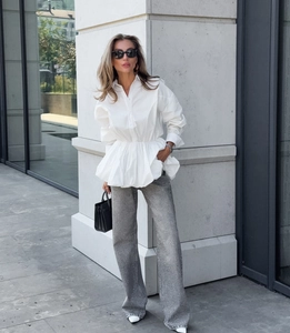 Close-up of a white cinched-waist blouse paired with sequined grey wide-leg trousers
