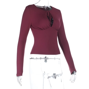 Detail of burgundy slim fit long sleeve top with teardrop cutout and lace-up neck design