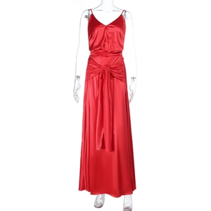 Detail of red satin evening gown showing silky texture and waist ribbon bow detail