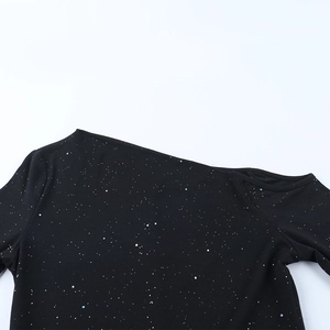 Detail of black off-the-shoulder dress fabric with sparkling silver star texture