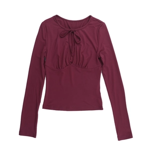 Detail of burgundy off-shoulder top showing pleated chest design and soft fabric texture