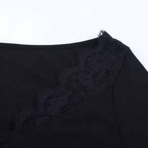 Close-up of intricate floral lace splicing and eyelash trim on the black V-neck top