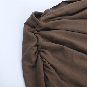 Detail shot of deep brown dress showing intricate ruching on high-quality knitted fabric