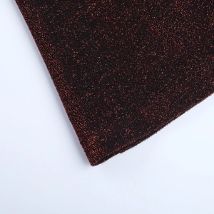 Gros plan sur le tissu pailleté bordeaux avec texture métallique détaillée et scintillement