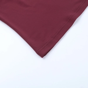 Detailed close-up of double-stitched hem on wine red slim fit long sleeve top