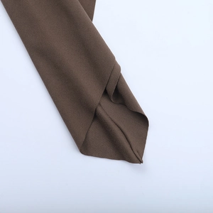 Detail of fine stitching and dark brown fabric texture on this off-shoulder summer dress