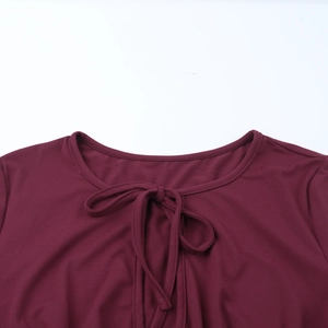 Close-up of burgundy slim-fit ribbed top with lace-up bow and cutout neck detail