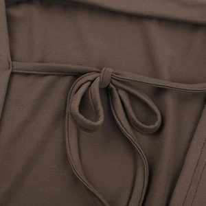 Detailed view of dark brown knitted dress featuring a central elegant bow tie design