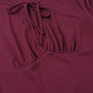 Detail of burgundy off-shoulder top showing lace-up neckline and gathered fabric texture