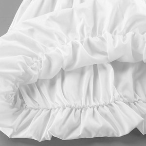 Detail of white cotton shirt featuring elastic smocked cuffs and ruffled edge texture
