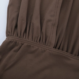 Detailed macro shot of dark brown fabric with precise pleats and fine knit texture