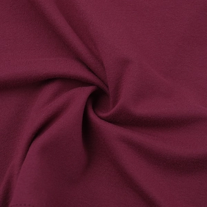 Detailed macro shot of burgundy knitted fabric texture with soft drapery and fine weave