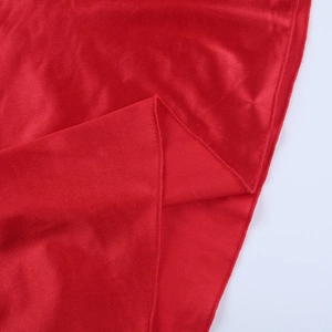 Close-up of red velvet fabric showing rich texture and fine overlock stitching details