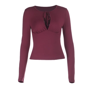 Close-up of burgundy slim top featuring a keyhole neckline with decorative tie detail