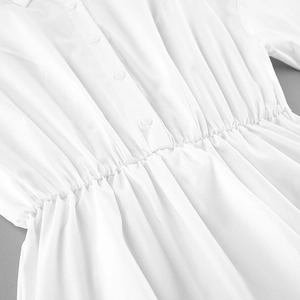 Detail of white cotton shirt showing elastic waist pleats and matching buttons