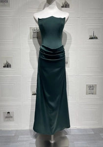 Detail of emerald green strapless gown with pleated waist and floor-length satin skirt