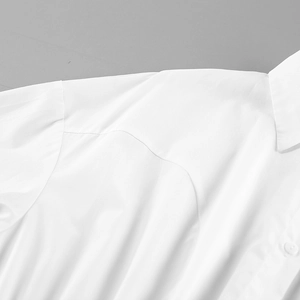 Detail shot of a white cotton shirt collar and button with smooth fabric texture