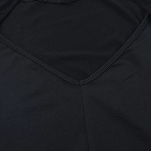 Detail des V-Ausschnitts und feiner Nähte an einem schwarzen Abendkleid mit Ärmeln