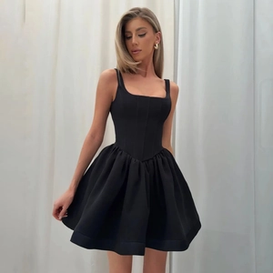 Detail of black corset-style mini dress with structured bodice and voluminous pleated skirt
