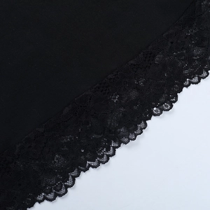 Detailed close-up of vintage black dress featuring delicate floral lace trim on sleeve