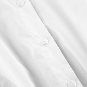 Detailed close-up of white cotton shirt front showing neat stitching and round buttons
