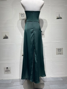 Detail of dark green satin tube dress featuring a slim fit back zipper and rear slit