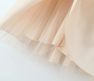 Detailed close-up of apricot layered tulle fabric showing the soft mesh texture and lining
