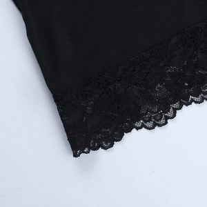 Detail of vintage black dress featuring intricate floral lace hem and textured fabric