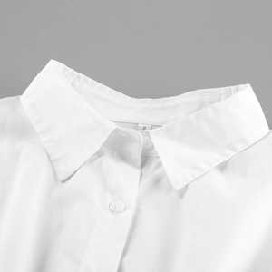 Close-up of a white cotton shirt collar with sharp lapels and a white round button detail