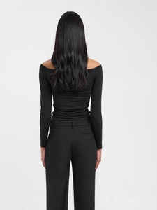 Back view of a sleek black off-shoulder long sleeve top with fitted trousers for women