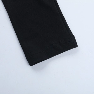 Detailed macro view of the double-stitched hem and knitted texture on a black Y2K mini dress
