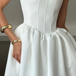 Detailed view of white strapless ball gown with boned corset and pleated satin skirt