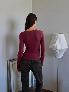 Slim fit burgundy long sleeve top and grey jeans shown from a back perspective