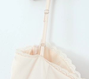 Detailed close-up of adjustable silk camisole straps with lace trim and silver hardware