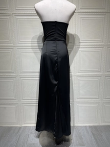 Rear view of black off-shoulder maxi dress showing satin finish and zipper closure detail