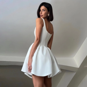Detail of elegant white satin backless puff dress with pleated skirt for party