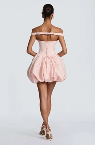 Detail of light pink mini bubble dress featuring a lace-up back and satin finish