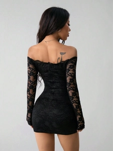 Detail of elegant black lace off-the-shoulder dress showing intricate floral texture