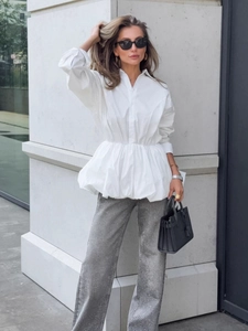 White cotton long-sleeve blouse with pleated waist and peplum hem on outdoor female model