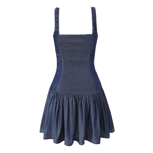 Detailed close-up of dark blue denim dress with shirred bodice and white contrast stitching
