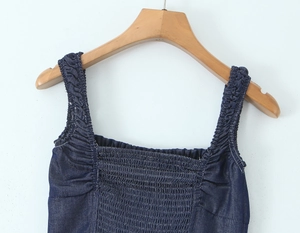 Detail of smocked elastic chest and ruffled straps on this dark blue denim dress