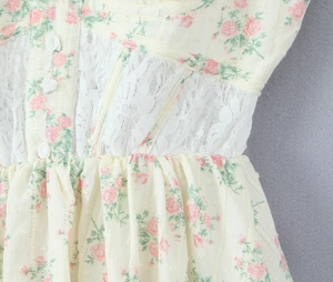Gros plan d'une robe fleurie avec dentelle blanche, motifs roses et détails de texture