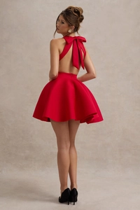 Vue arrière d'une élégante robe de cocktail rouge avec grand nœud et dos nu prononcé