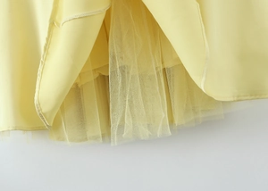 Detail of light yellow dress showing mesh layering and precise stitching quality