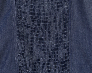 Detailed macro view of smocking shirring on navy denim dress with contrast stitching